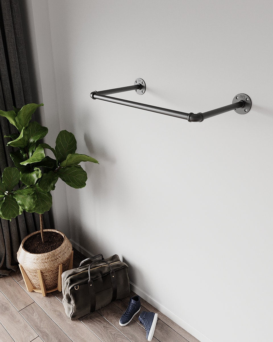 Clothes hanging on a wall-mounted pipe rack.