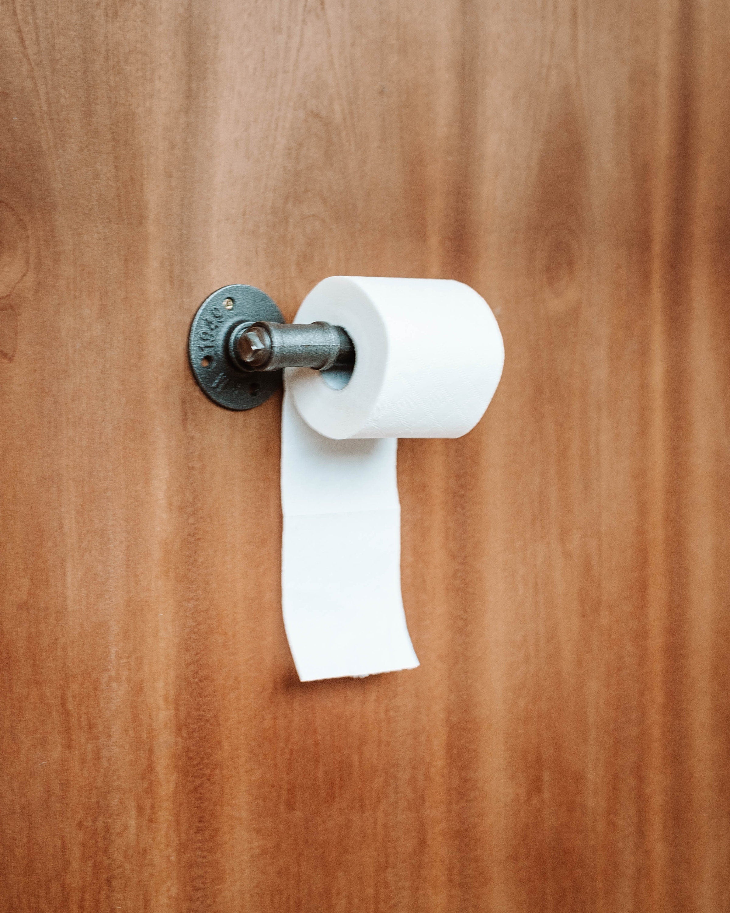 Contemporary Toilet Roll Holder holding toiletroll, highlighting its sleek and wall-mounted design.