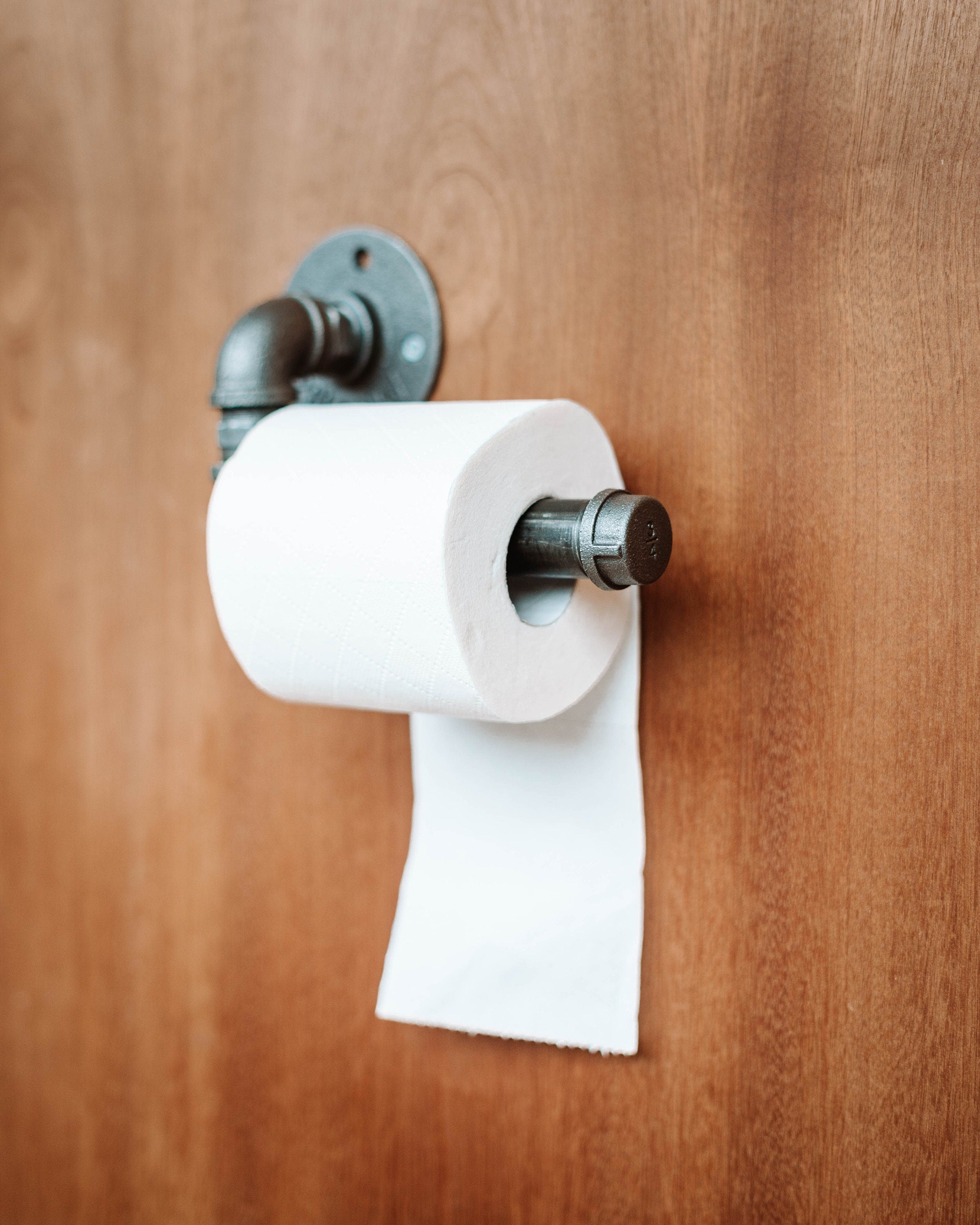 Toilet Roll Holder mounted on the wall, showcasing its sleek and practical design.