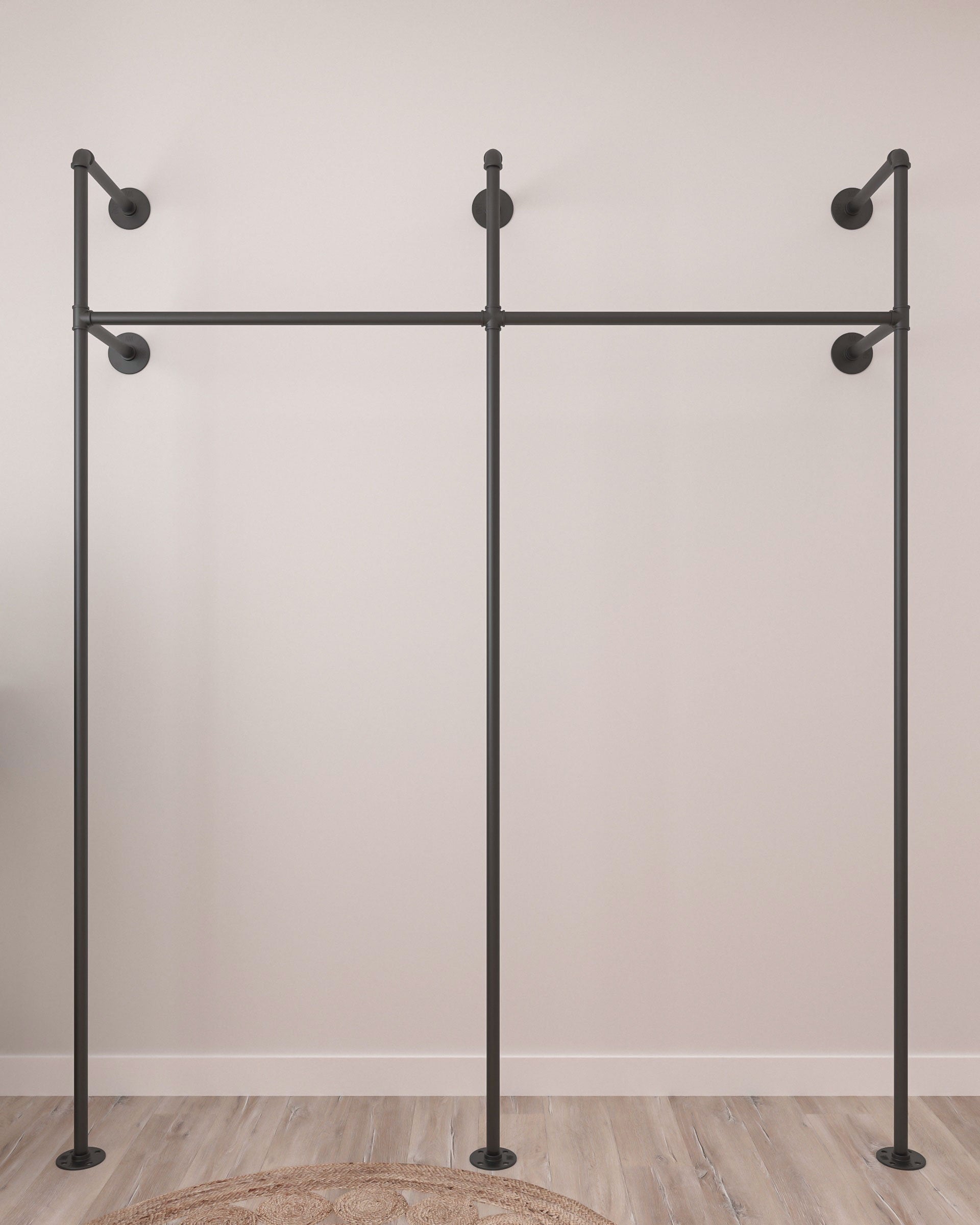 Glide Pipe Garment Rack wall-mounted, showcasing its industrial design and functionality for hanging clothing