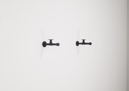 Wall-mounted industrial shelf with a wooden shelf and metal pipe fittings, featuring a hanging rail for clothes storage.