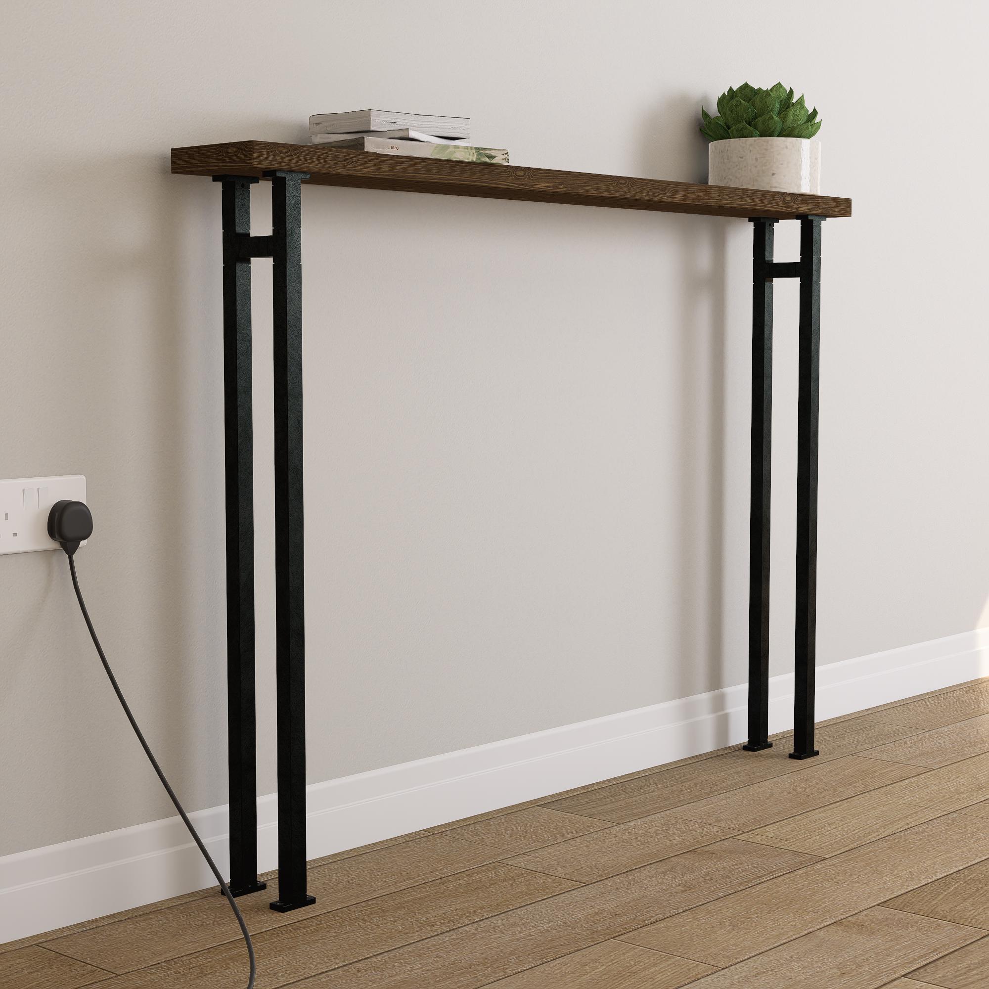 Wooden console table with black metal legs against a white wall.