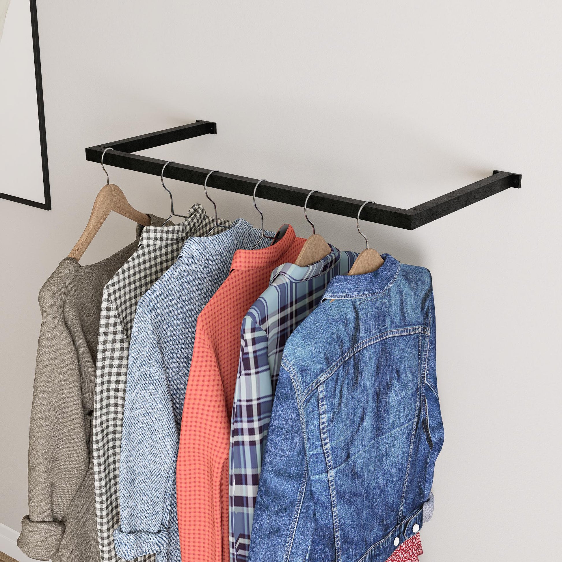 wall-mounted clothing rack with wooden hangers holding shirts and jackets, placed against a neutral wall with minimal decor.