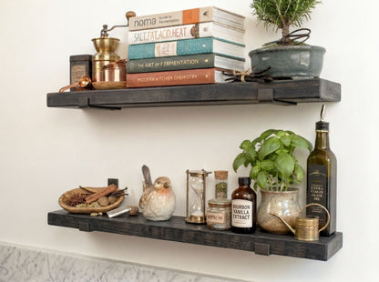 a set of dark wooden shelves displaying various items, including books, spices, a potted plant, and other decorative objects.