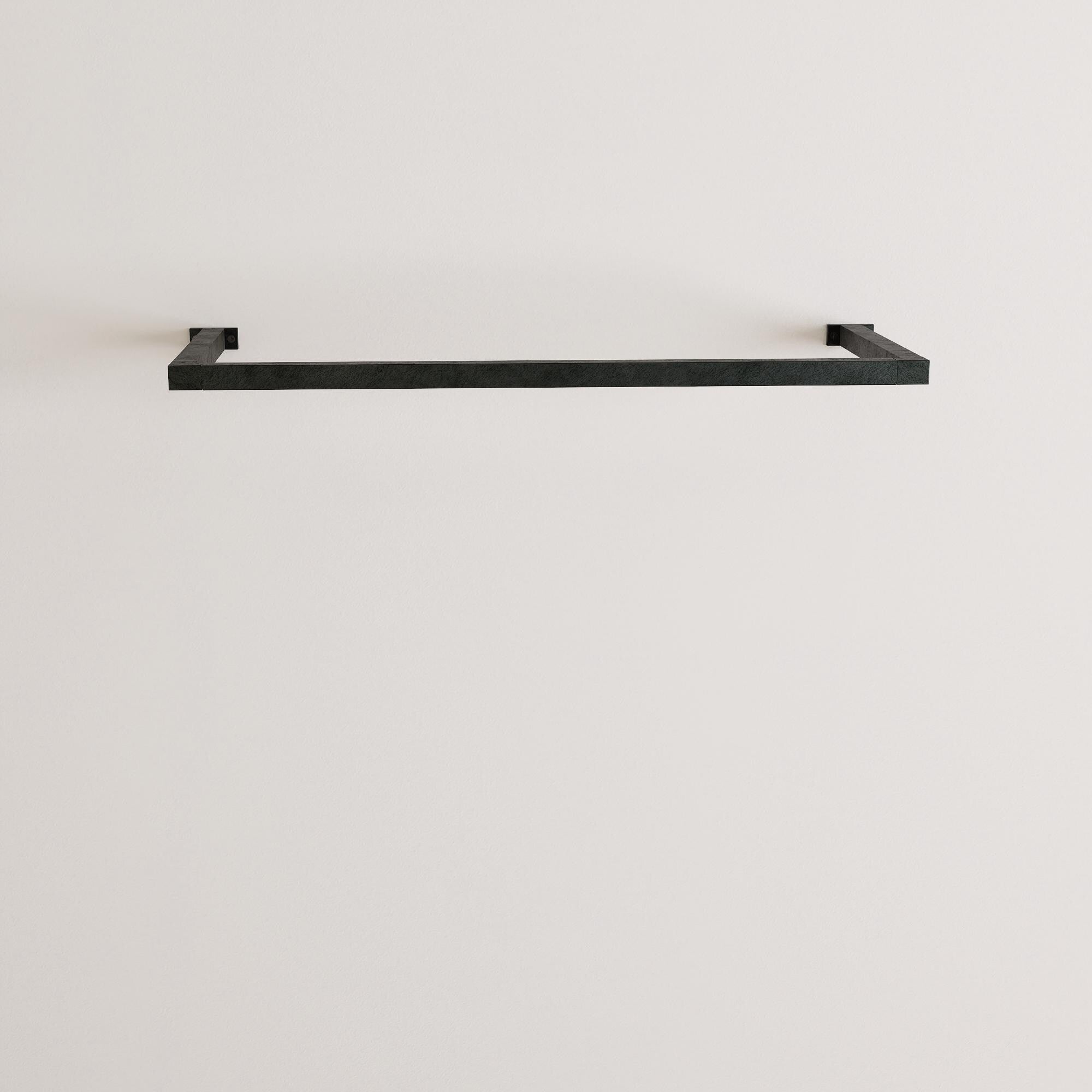 wall-mounted clothing rack with wooden hangers holding shirts and jackets, placed against a neutral wall with minimal decor.