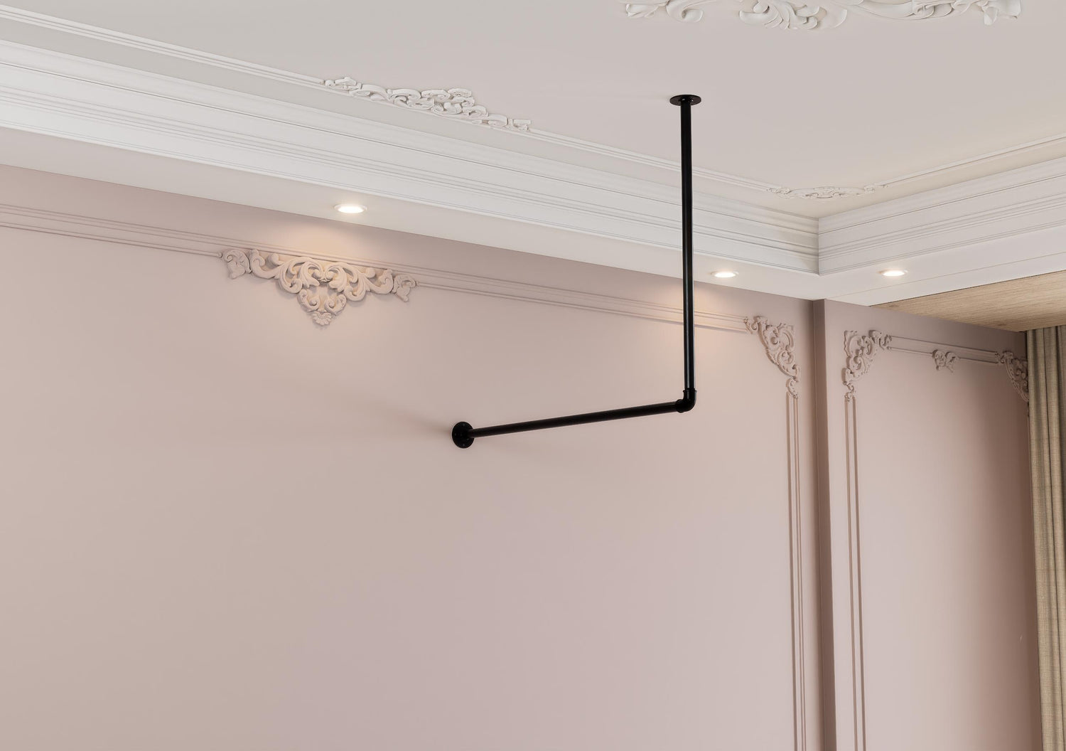 a room with a pink wall and a black pipe
