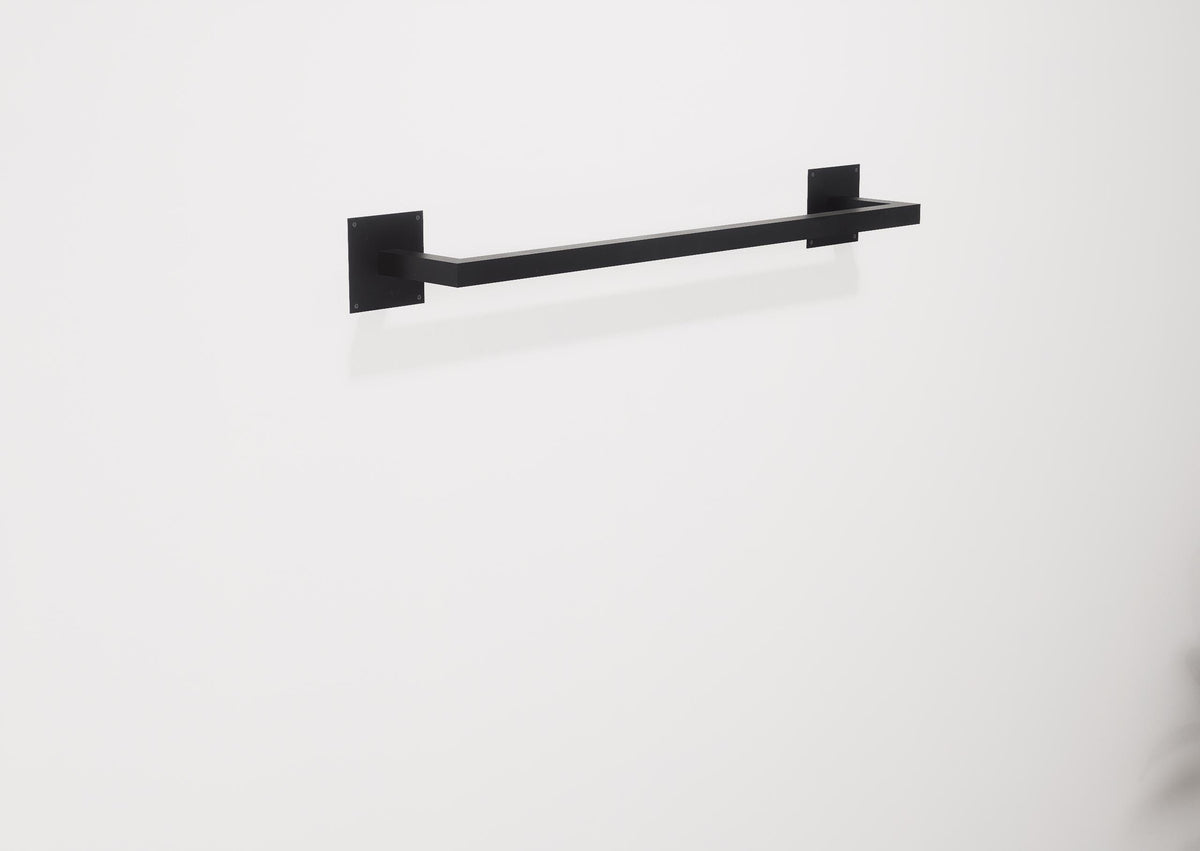 Minimalist square towel holder made from sturdy metal, featuring an industrial design. Ideal for organizing towels in the bathroom, adding a modern touch to decor. Durable and easy to install.