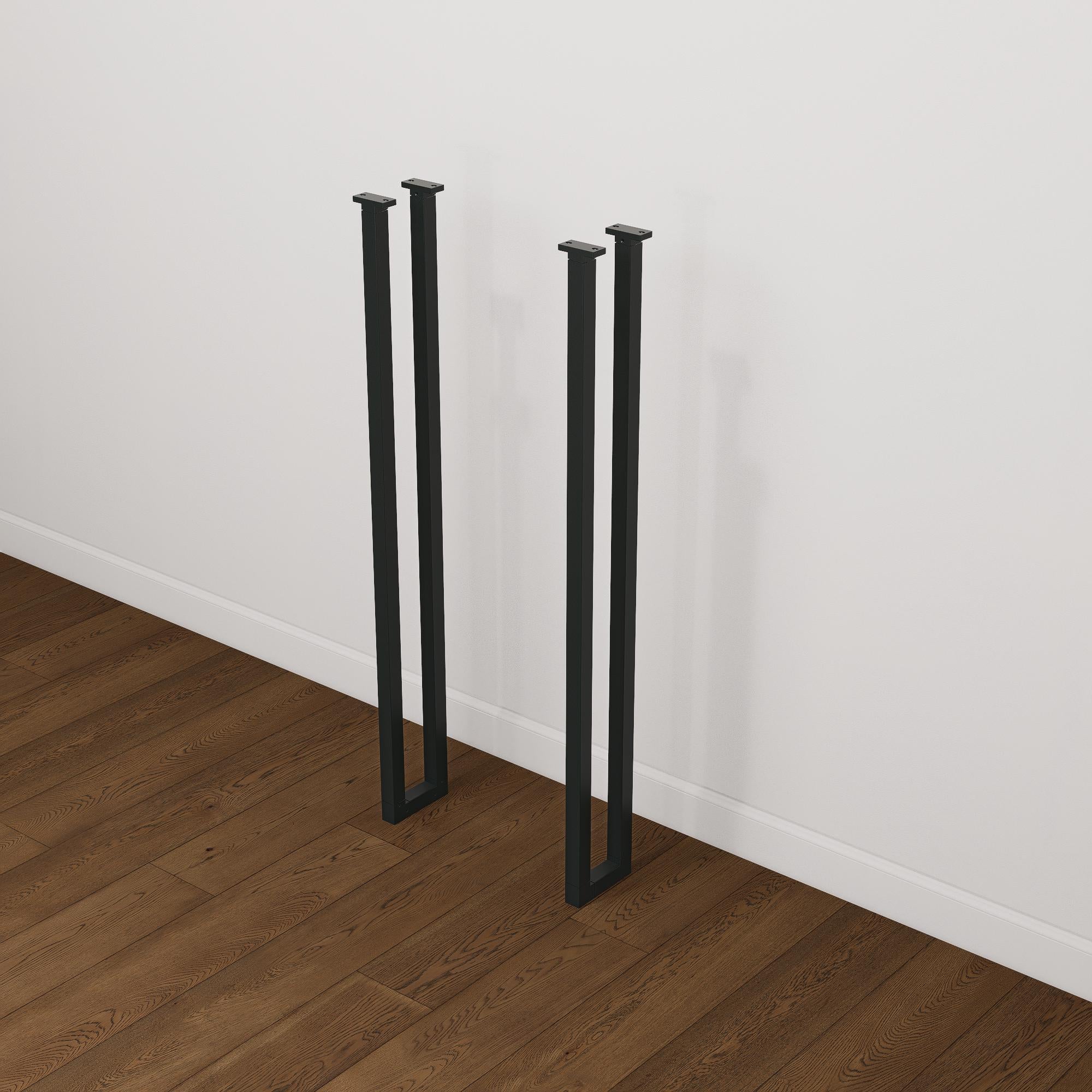 Set of two tall black industrial steel box frame table legs designed for breakfast bars or console tables, standing on wood flooring.
