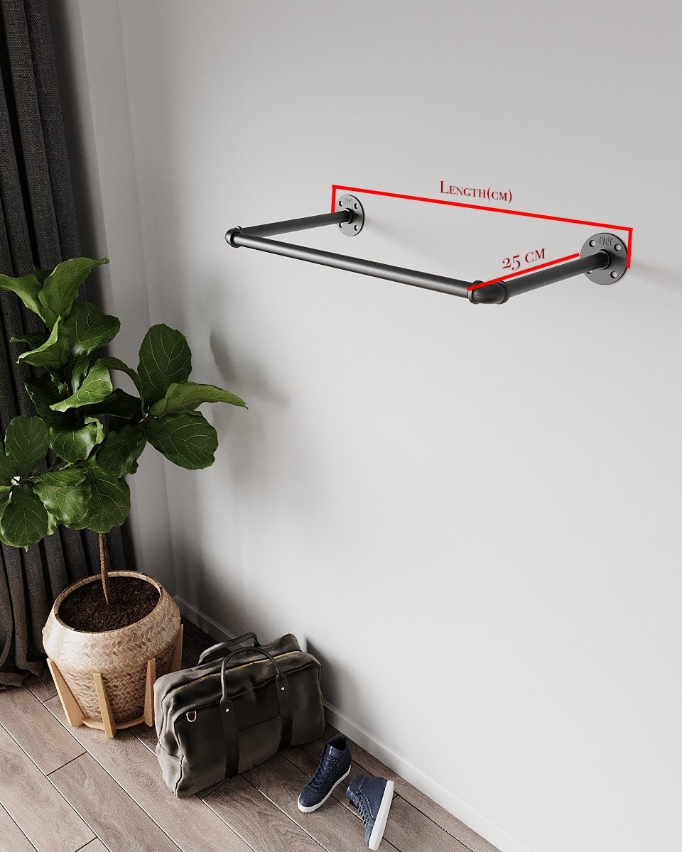 Clothes hanging on a wall-mounted pipe rack.