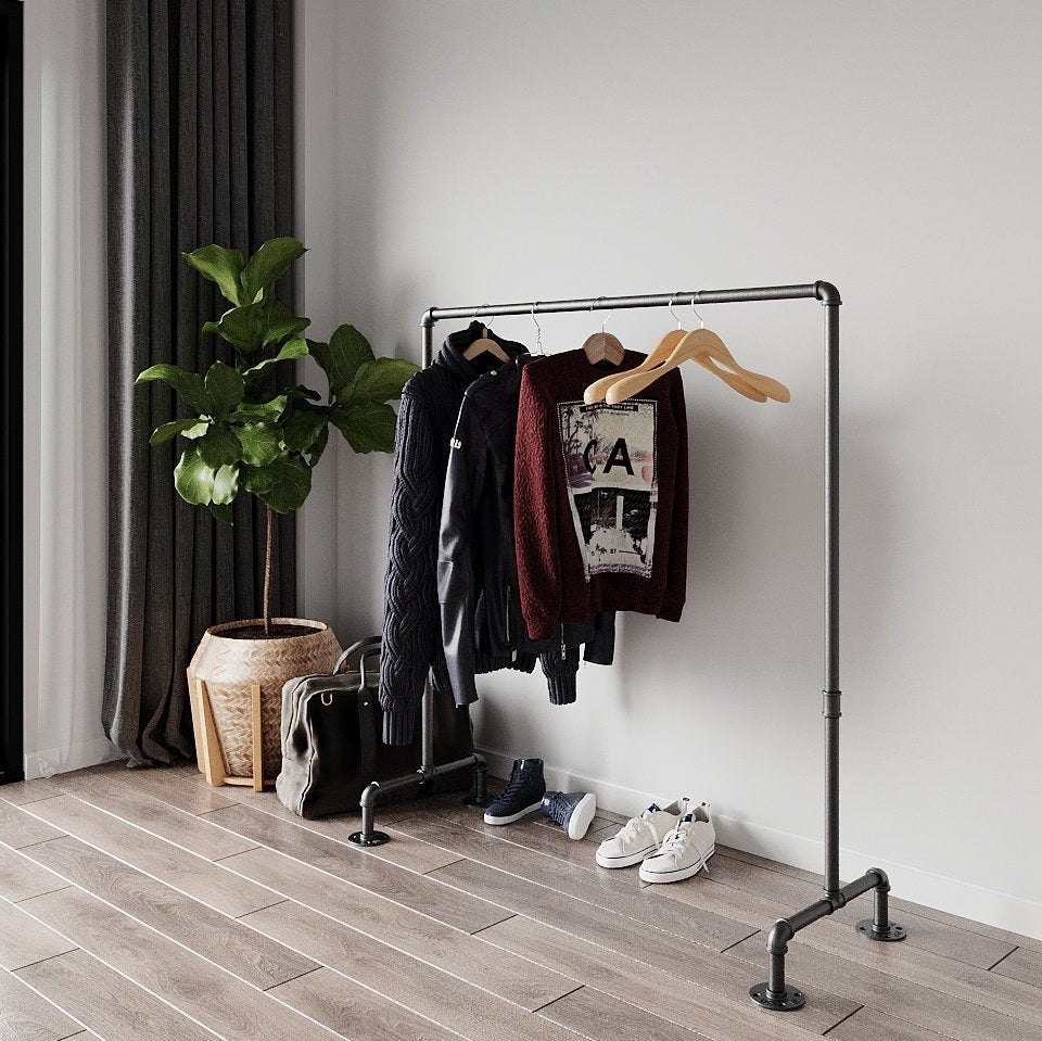 Estar Freestanding Pipe Clothes Rack, a robust and portable Open Wardrobe, suitable for hanging clothes and storing accessories in various aesthetic settings.