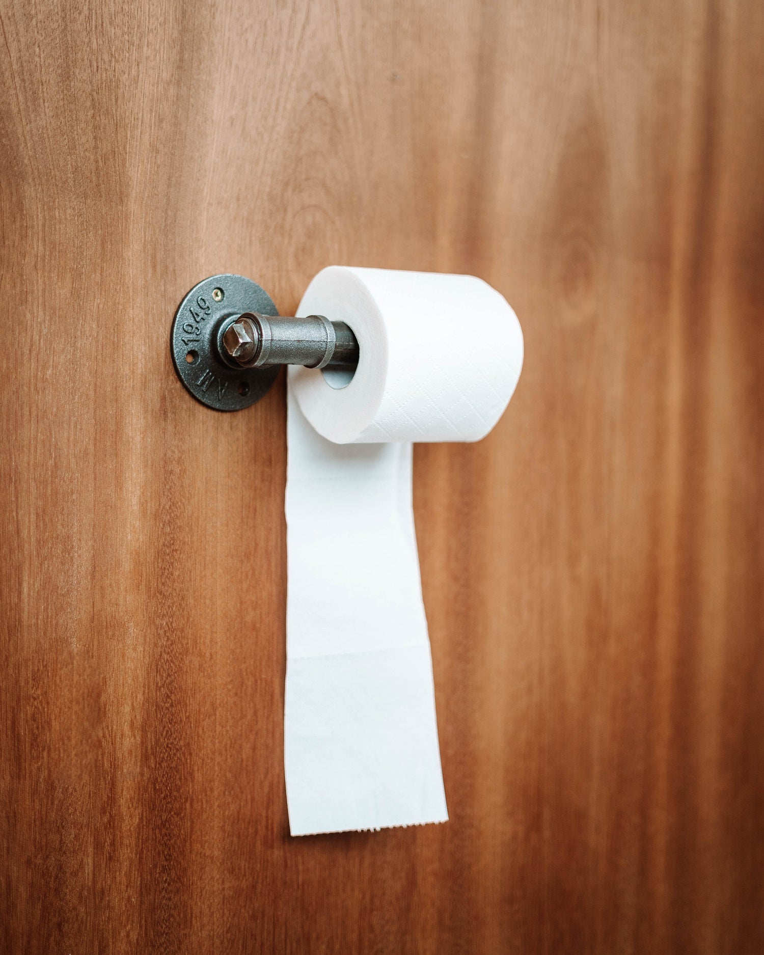 Contemporary Toilet Roll Holder holding toiletroll, highlighting its sleek and wall-mounted design.